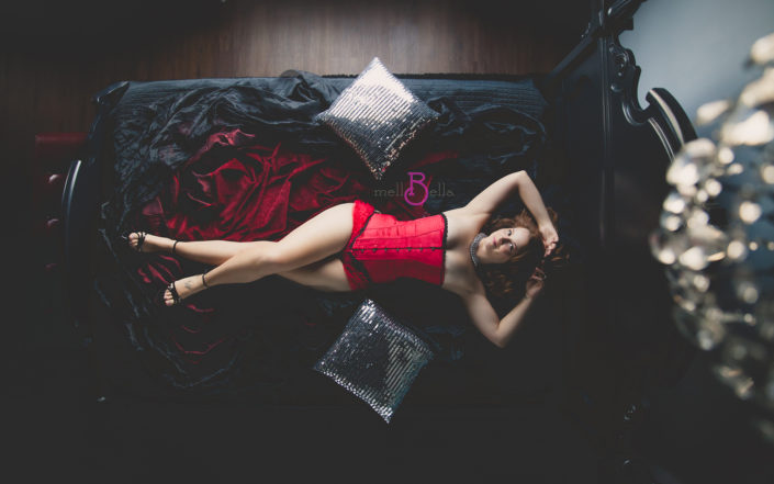 mellbella boudoir over the bed camera with a red corset and silver pillows