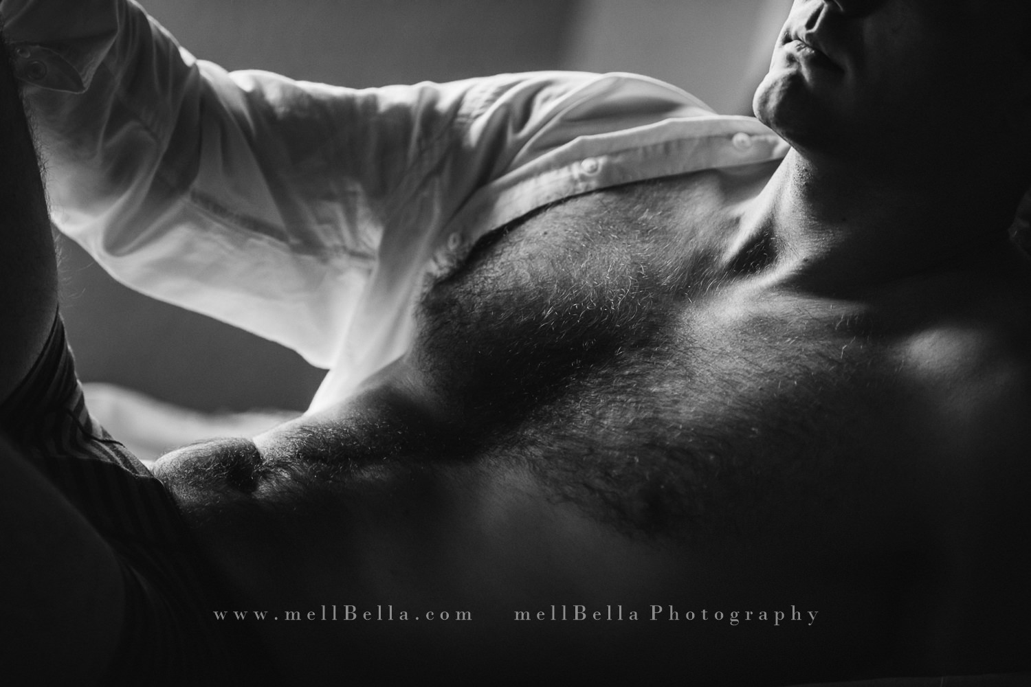 black and white close up of a male in a white unbuttoned shirt